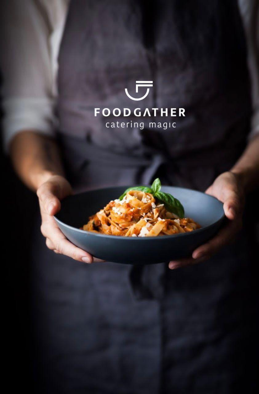 Person holding a bowl of pasta garnished with basil, featuring the FoodGather logo above.