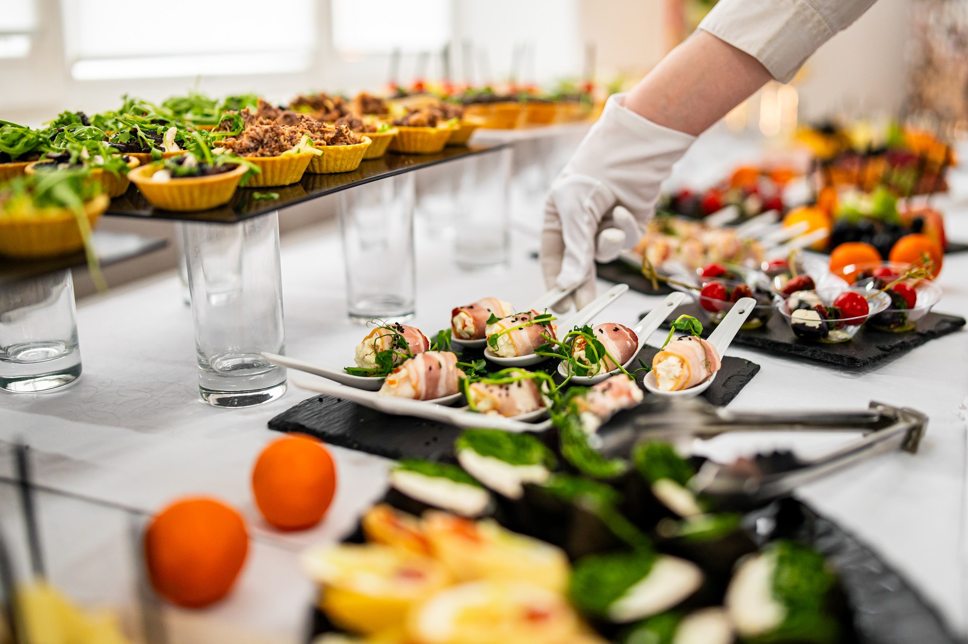 woman hands of a waiter prepare food for a buffet table in a restaurant